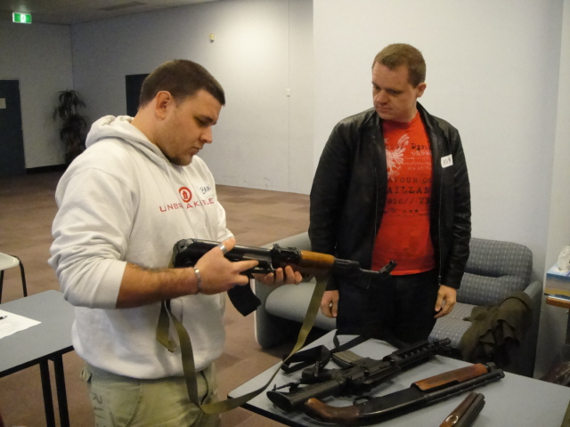 Students learning how to lock and load assault rifles and shotguns